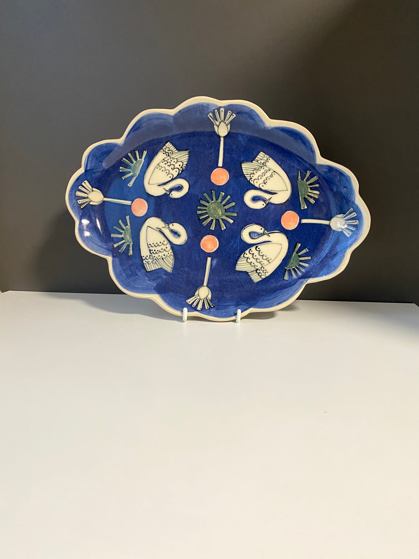 Ceramic Scallop Edge Platter with Swans Pattern against Blue Background