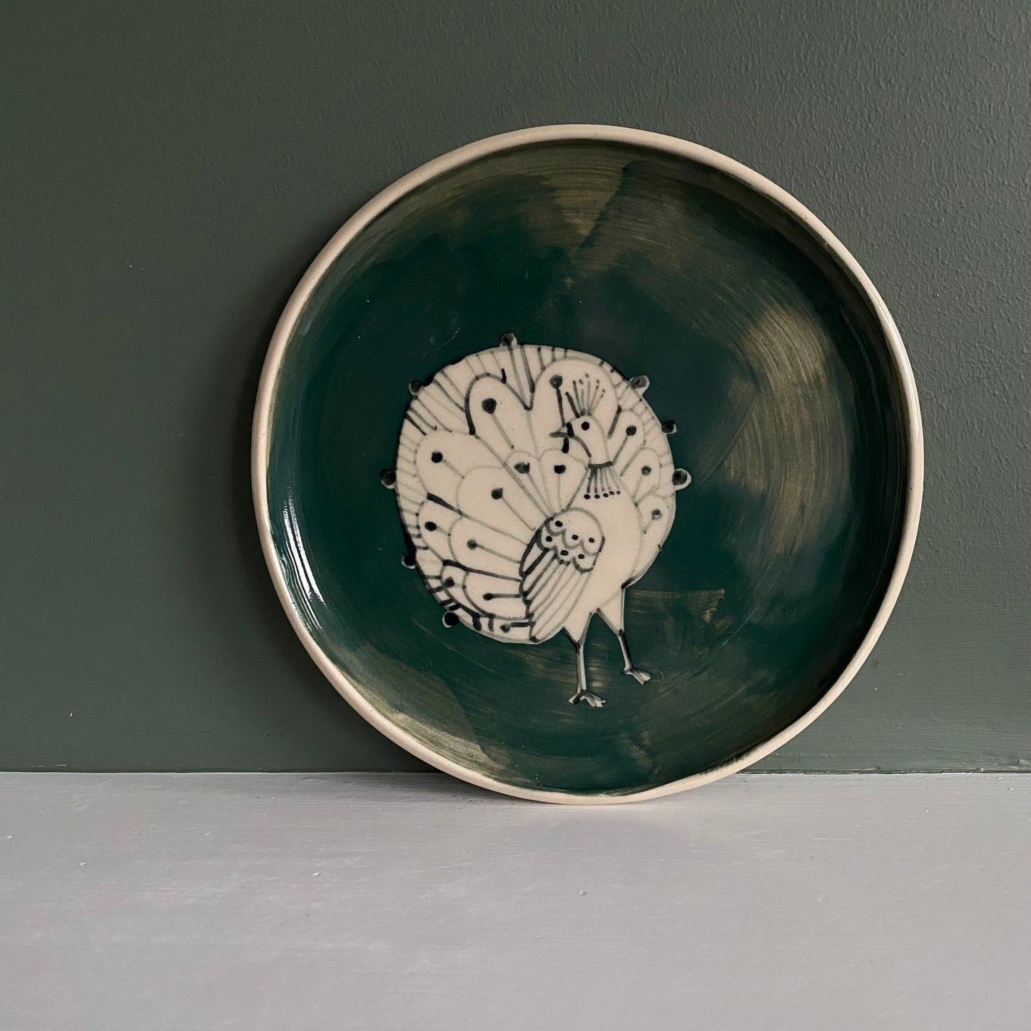 Peacock small Stoneware plate with Bird Illustrated round dark teal colour with bird line illustration.